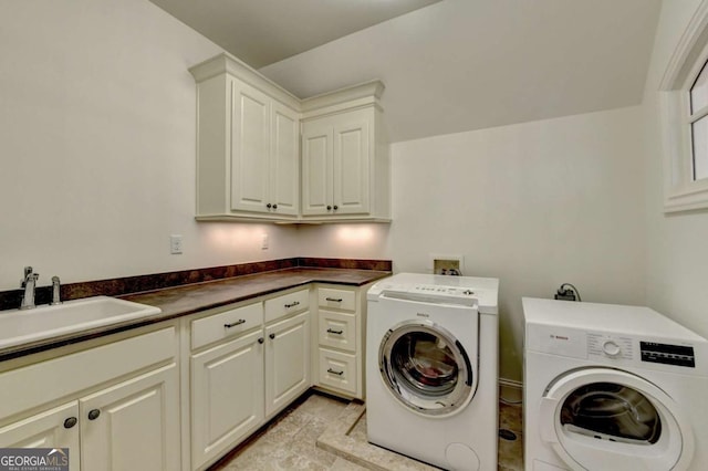 washroom with a sink, washer and clothes dryer, and cabinet space