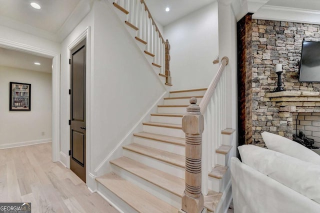 stairs featuring wood finished floors, baseboards, ornamental molding, and recessed lighting