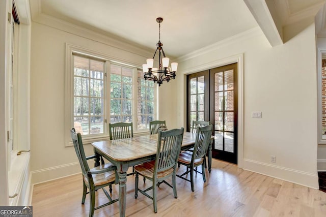 dining area featuring baseboards, light wood finished floors, a notable chandelier, and a healthy amount of sunlight