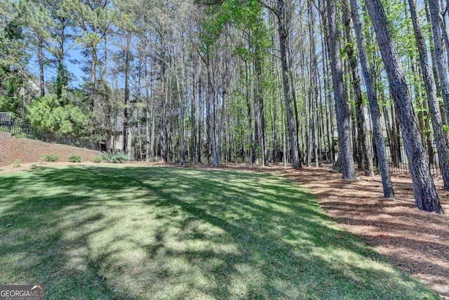 view of yard featuring a view of trees and fence
