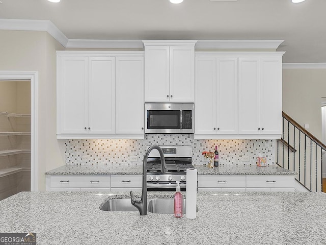 4343 Ainsley Mill Ln, Duluth, GA 30097 - kitchen featuring stainless steel appliances, white cabinets, a sink, and crown molding