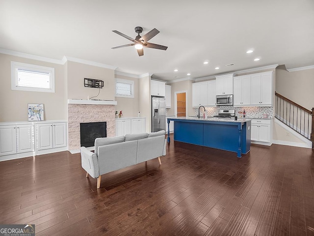 4343 Ainsley Mill Ln, Duluth, GA 30097 - living area featuring a ceiling fan, dark wood-style floors, ornamental molding, and stairs
