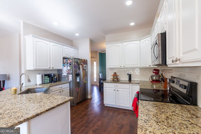 kitchen with a sink, white cabinets, appliances with stainless steel finishes, and light stone countertops