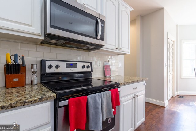 kitchen featuring stainless steel appliances, tasteful backsplash, white cabinetry, and dark wood finished floors