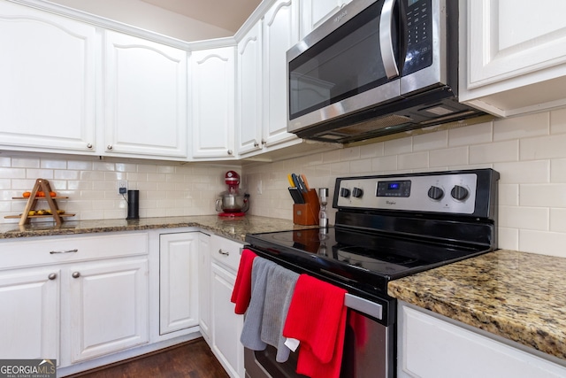 kitchen featuring white cabinets, stone countertops, backsplash, and appliances with stainless steel finishes