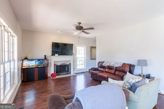 living room with a fireplace, dark wood-style floors, and ceiling fan