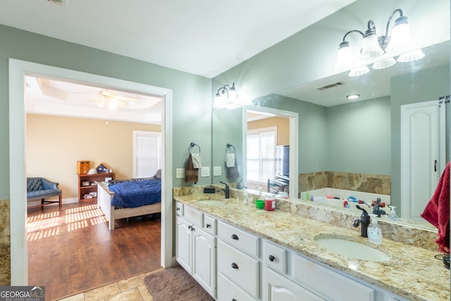 ensuite bathroom with double vanity, a sink, ensuite bath, and visible vents