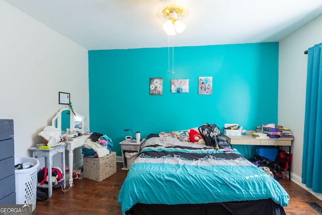 bedroom featuring visible vents and wood finished floors