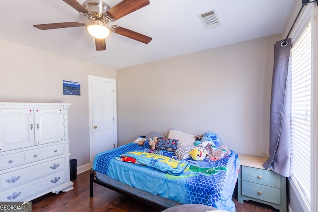 bedroom featuring visible vents, baseboards, a ceiling fan, and dark wood finished floors