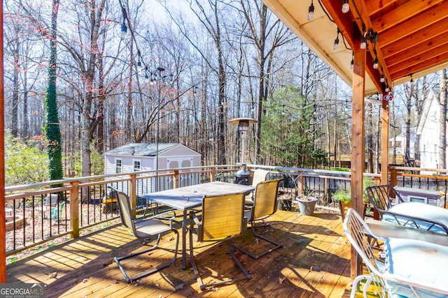 wooden deck featuring outdoor dining space and an outdoor structure
