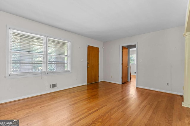 3944 Woburn Dr, Tucker, GA 30084 - unfurnished room with decorative columns, light wood finished floors, visible vents, and baseboards