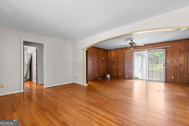 3944 Woburn Dr, Tucker, GA 30084 - unfurnished living room with arched walkways, light wood finished floors, baseboards, and a ceiling fan