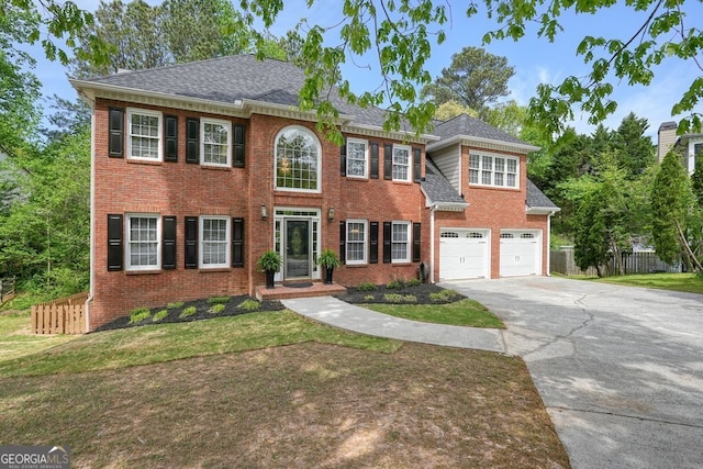colonial-style house with driveway, brick siding, a garage, and roof with shingles