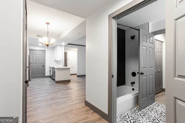 1074 Peachtree Walk NE Unit 115, Atlanta, GA 30309 - hallway with a chandelier and light wood-style floors