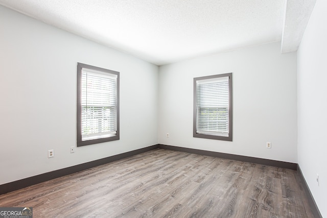 1074 Peachtree Walk NE Unit 115, Atlanta, GA 30309 - empty room with wood finished floors and a textured ceiling