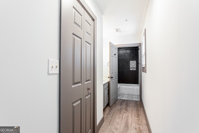 1074 Peachtree Walk NE Unit 115, Atlanta, GA 30309 - corridor featuring light wood-style floors and baseboards