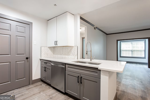 1074 Peachtree Walk NE Unit 115, Atlanta, GA 30309 - kitchen featuring stainless steel dishwasher, a peninsula, light wood-type flooring, white cabinetry, and tasteful backsplash