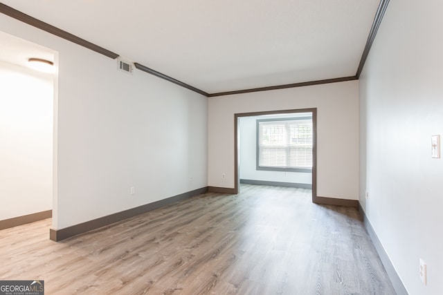 1074 Peachtree Walk NE Unit 115, Atlanta, GA 30309 - unfurnished room with crown molding and light wood-style floors