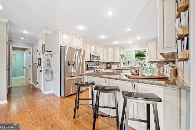 524 Allison Ln, Ball Ground, GA 30107 - kitchen with stainless steel appliances, ornamental molding, a peninsula, dark stone countertops, and tasteful backsplash