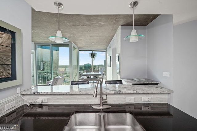 3324 Peachtree Rd NE Unit 1518, Atlanta, GA 30326 - kitchen with stone countertops, a sink, and hanging light fixtures