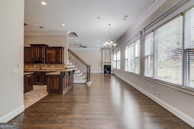 476 Walnut Rd, Hoschton, GA 30548 - kitchen with crown molding, light countertops, a chandelier, open floor plan, and tasteful backsplash