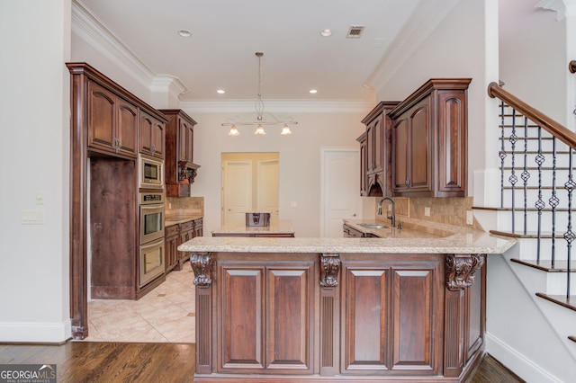 476 Walnut Rd, Hoschton, GA 30548 - kitchen with appliances with stainless steel finishes, a peninsula, light stone countertops, backsplash, and ornamental molding