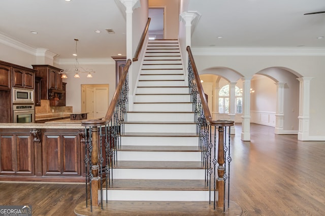 476 Walnut Rd, Hoschton, GA 30548 - stairway with crown molding, wood finished floors, decorative columns, and arched walkways
