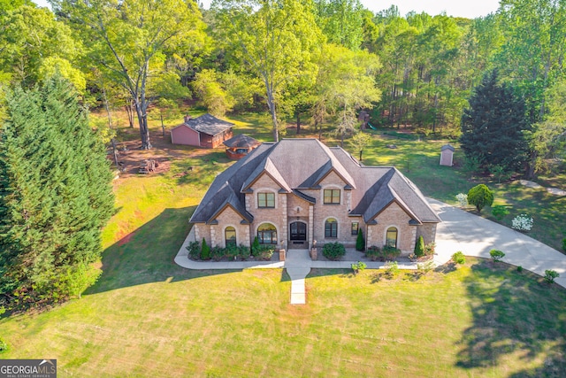 476 Walnut Rd, Hoschton, GA 30548 - view of front facade with brick siding, a front lawn, roof with shingles, and an outbuilding