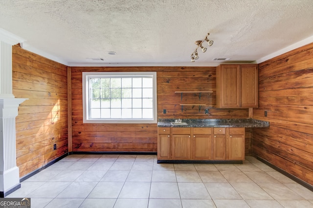 476 Walnut Rd, Hoschton, GA 30548 - kitchen with wooden walls, a textured ceiling, brown cabinets, and dark stone countertops