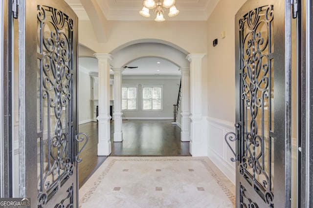 476 Walnut Rd, Hoschton, GA 30548 - entryway with arched walkways, ornamental molding, wood finished floors, wainscoting, and a chandelier
