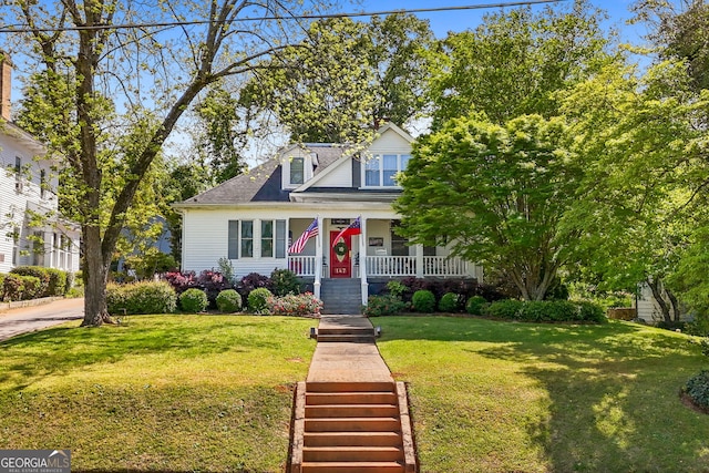 view of front of home featuring a porch, a shingled roof, and a front lawn