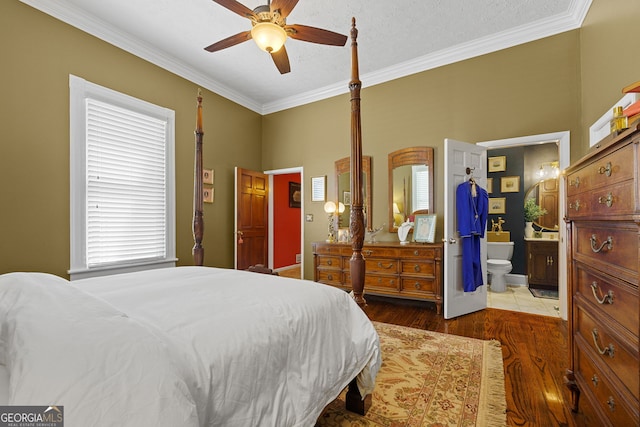 bedroom with crown molding, wood finished floors, a ceiling fan, and connected bathroom