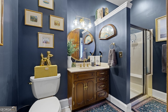 bathroom featuring a shower stall, vanity, baseboards, and toilet