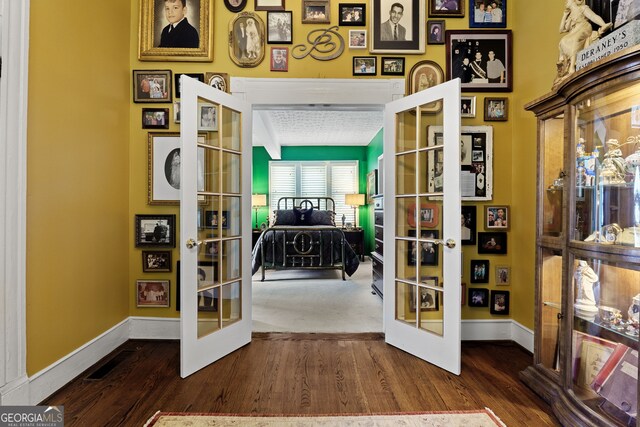 doorway with dark wood-type flooring, french doors, baseboards, and visible vents