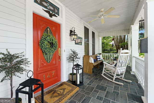 entrance to property featuring a porch and ceiling fan