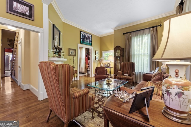 living room with crown molding, baseboards, and wood finished floors