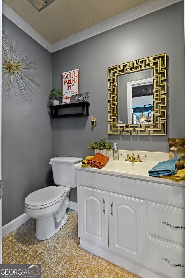 bathroom with crown molding, vanity, visible vents, toilet, and baseboards