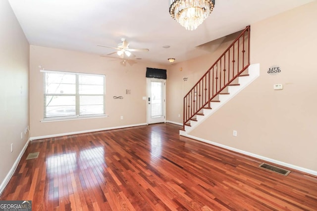 entrance foyer featuring visible vents, baseboards, stairway, ceiling fan with notable chandelier, and wood-type flooring