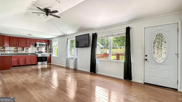 kitchen featuring baseboards, appliances with stainless steel finishes, dark brown cabinets, and plenty of natural light