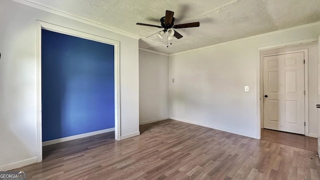 unfurnished bedroom featuring baseboards, wood finished floors, and a textured ceiling