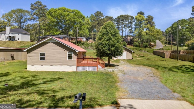 view of property exterior with a yard, a deck, crawl space, and an outdoor structure