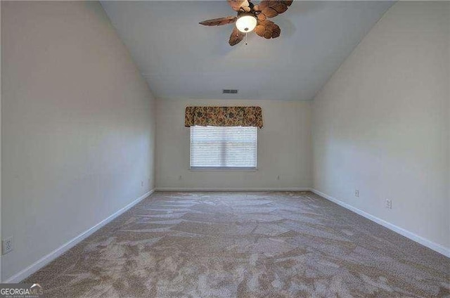 carpeted spare room featuring visible vents, baseboards, a ceiling fan, and lofted ceiling