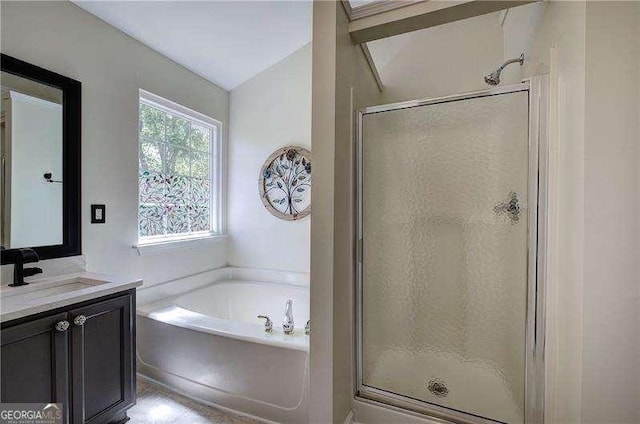 bathroom with a stall shower, a garden tub, and vanity