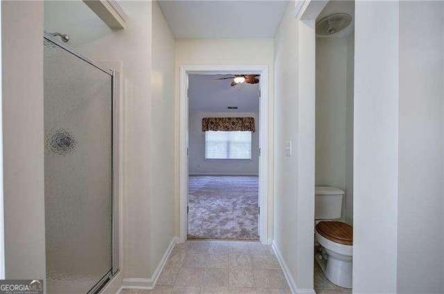 full bath featuring a shower stall, baseboards, and toilet