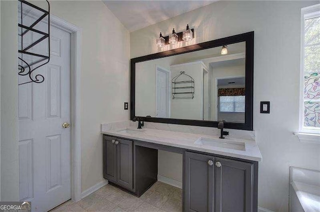full bathroom featuring plenty of natural light, double vanity, and a sink