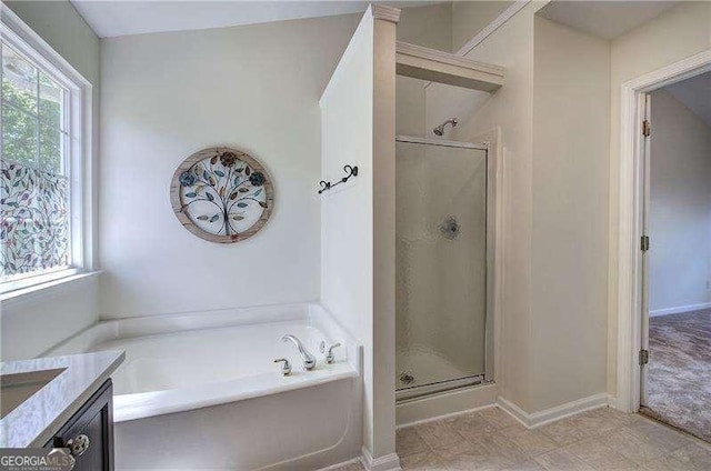 bathroom with a shower stall, vanity, baseboards, and a garden tub