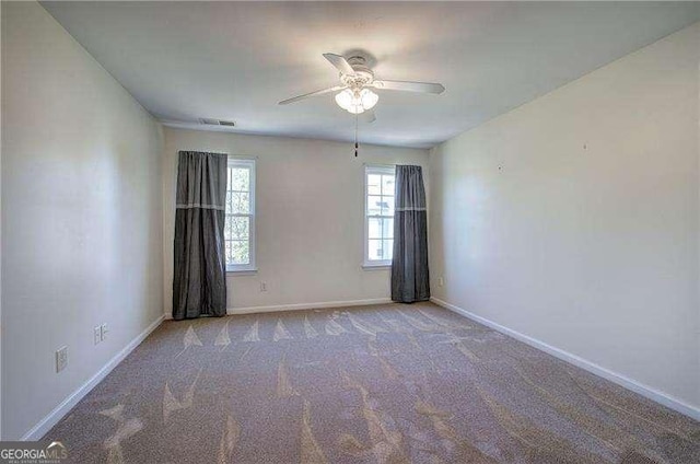 empty room with ceiling fan, baseboards, carpet flooring, and visible vents