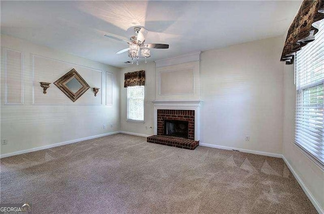unfurnished living room with a fireplace, carpet floors, a ceiling fan, and a healthy amount of sunlight