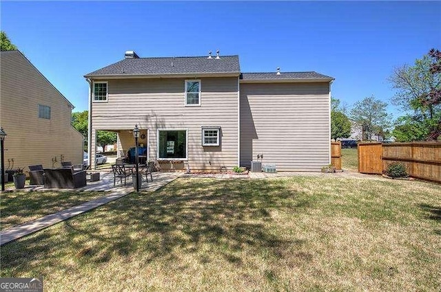 back of property with a yard, fence, cooling unit, and a patio