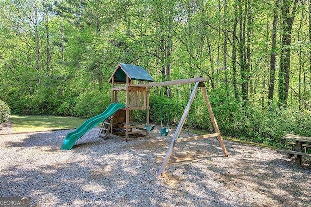 view of jungle gym featuring a forest view